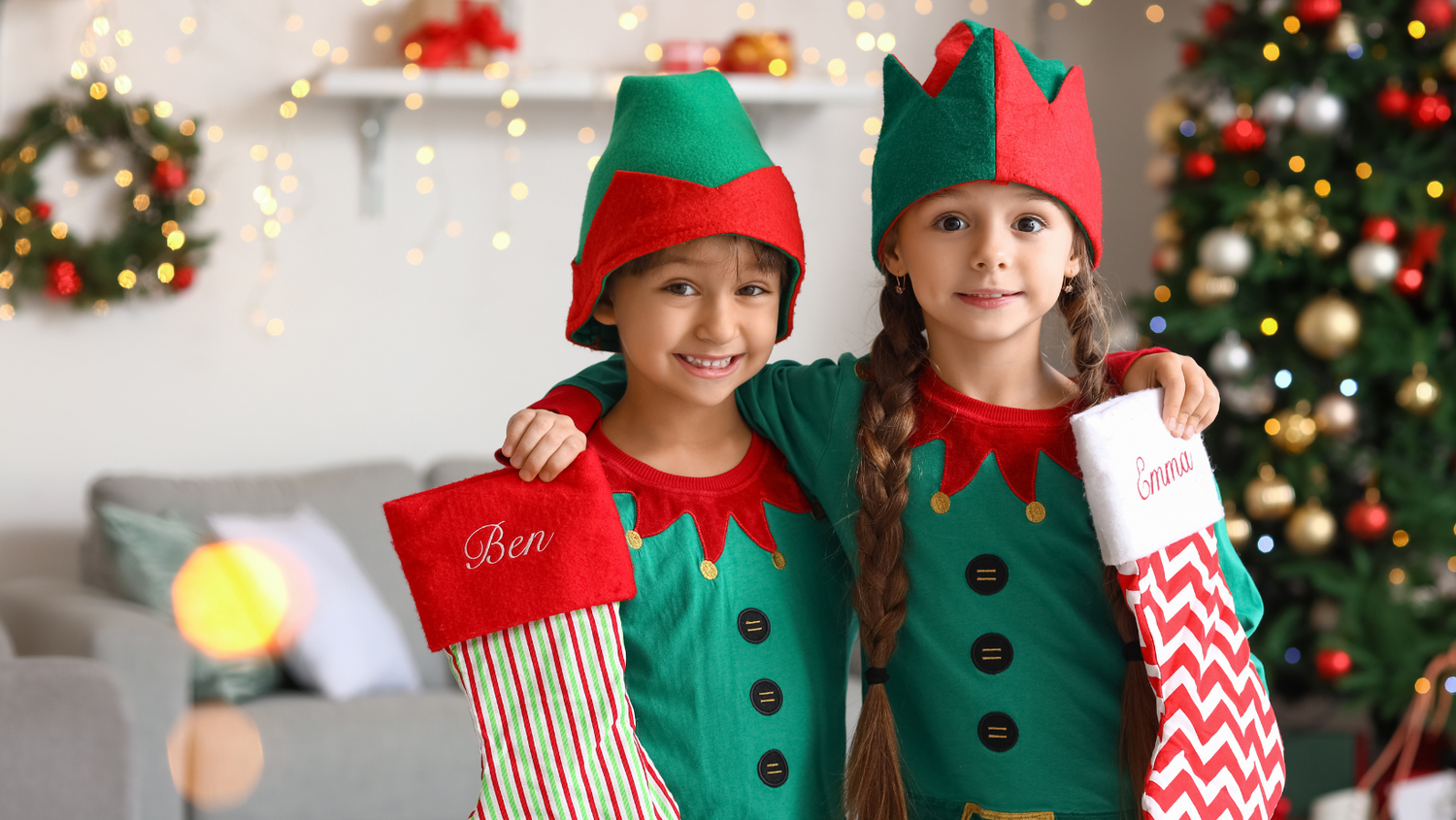 Children dressed as christmas elves holding christmas stockings
