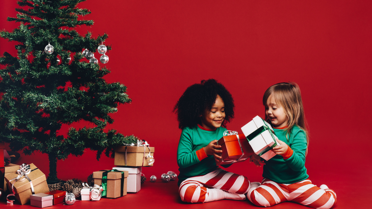 Christmas gifts under a tree and children smiling