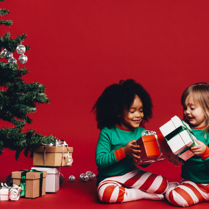 Christmas gifts under a tree and children smiling