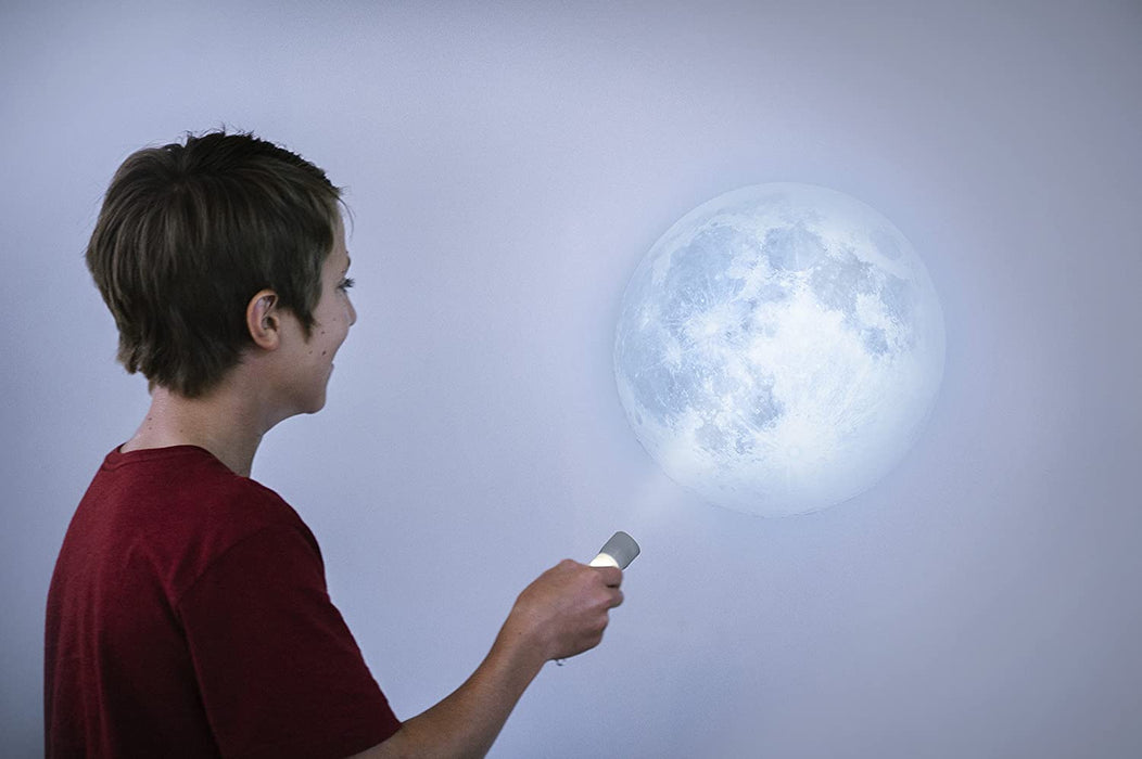 child shining moon torch on wall
